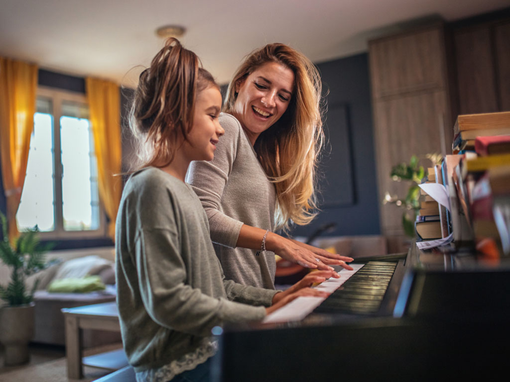 Child learning piano with teacher